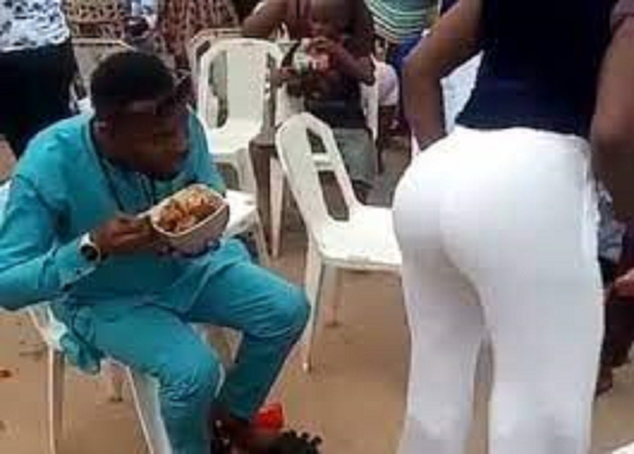 un homme avec un plat en mains, regardant les fesses d'une femme en pantalon blanc