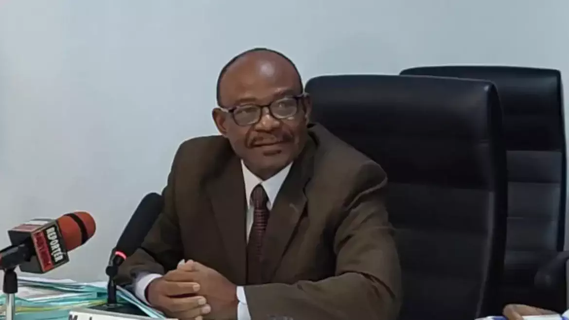 Jean-Baptiste Elias speaking at a podium during a press conference on tax clearance for elections in Benin.