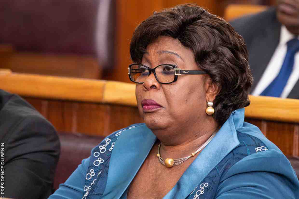 Mathys Adidjatou, Minister of Labor and Public Service, speaking at a podium during an event.