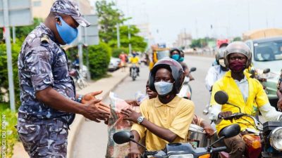 Un agent de la police républicaine en train de sensibiliser les motocyclistes sur le respect des règles de sécurité routière