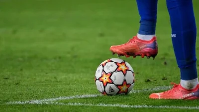 Un joueur qui a un pied sur un ballon de foot