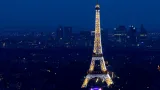 Tour Eiffel illuminée avec le quartier d'affaires de La Défense en arrière-plan, lors du 14 juillet à Paris.