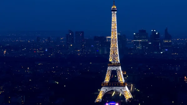 Tour Eiffel illuminée avec le quartier d'affaires de La Défense en arrière-plan, lors du 14 juillet à Paris.