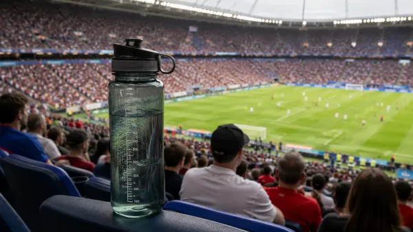 Gourde d’eau transparente au premier plan dans un stade de football bondé