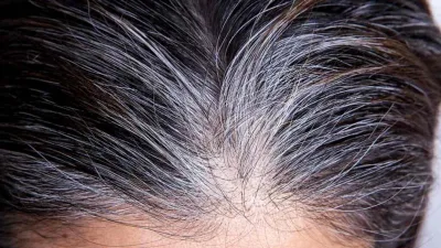 la tête d'une femme dévoilant des cheveux au milieu des cheveux noirs