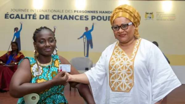 Veronique Tognifodé aux côtés d'une personne en situation de handicap lors d'une remise de carte d'égalité des chances.