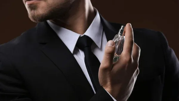 un homme en train de se parfumer