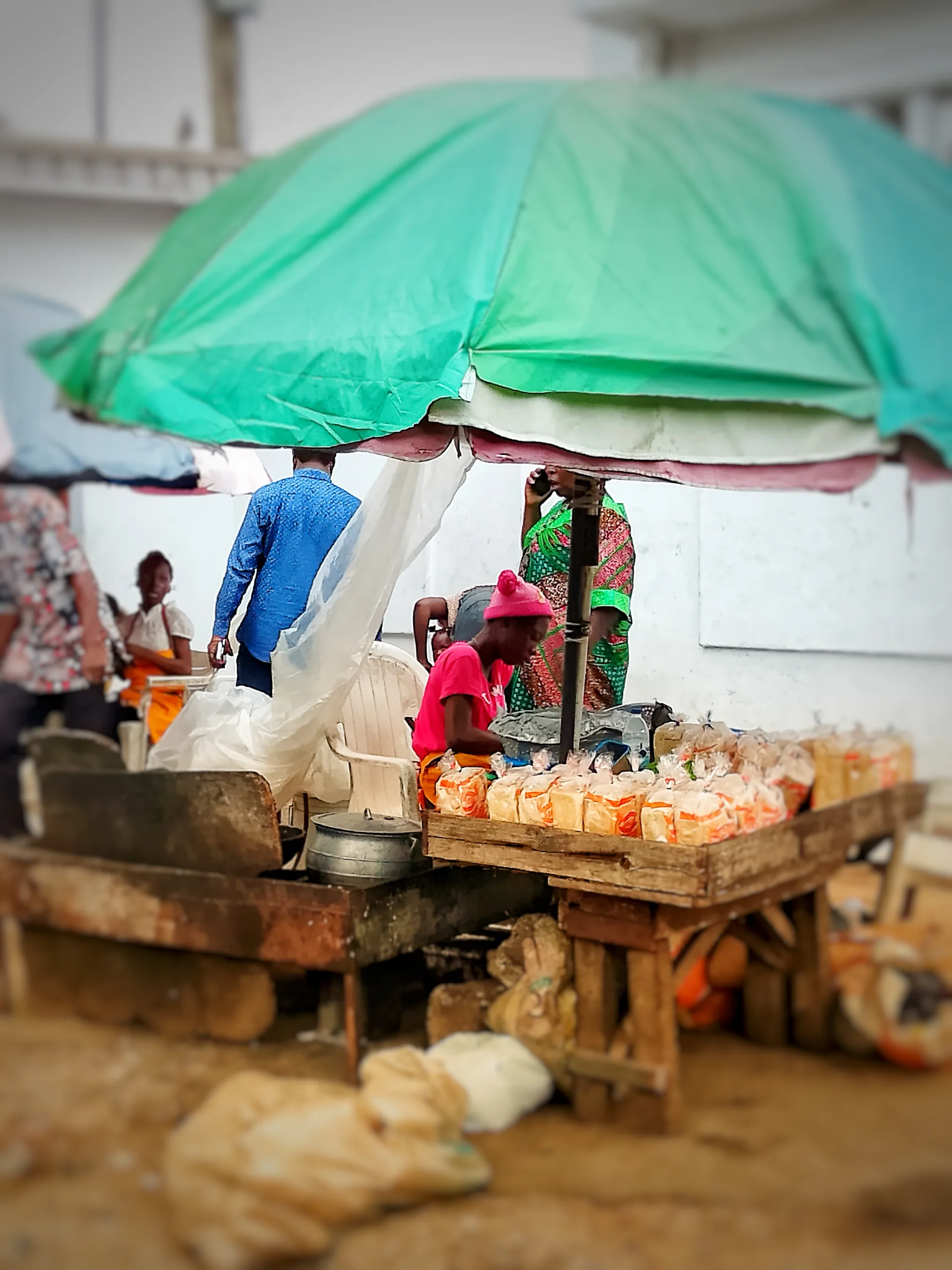 Une femme fait frire et vend de l’akara, des haricots et du pain au bord d’une route au Nigeria