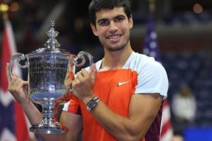Carlos Alcaraz souriant, tenant le trophée de l'US Open, célébrant sa victoire.