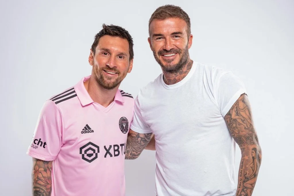 Lionel Messi et David Beckham souriant ensemble lors d'un événement sportif.