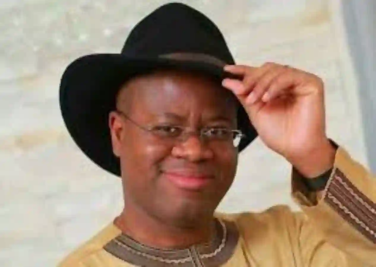 Pasteur Edgard Guidibi lors d'une conférence, regard sérieux, en arrière-plan flou.