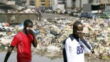 Des hommes se protègent des odeurs nauséabondes le 13 septembre 2006 devant une décharge dans un quartier d'Abidjan. Une importante quantité de déchets toxiques, déversée par une multinationale néerlandaise dans la capitale ivoirienne, se trouve en mer et à proximité de zones maraîchères, a déclaré un représentant de l'ONU, craignant une contamination de la chaîne alimentaire. Selon les autorités ivoiriennes, six personnes, dont quatre enfants, sont décédées et 10 000 ont consulté dans plus de 30 centres de santé depuis le déversement des déchets en août.