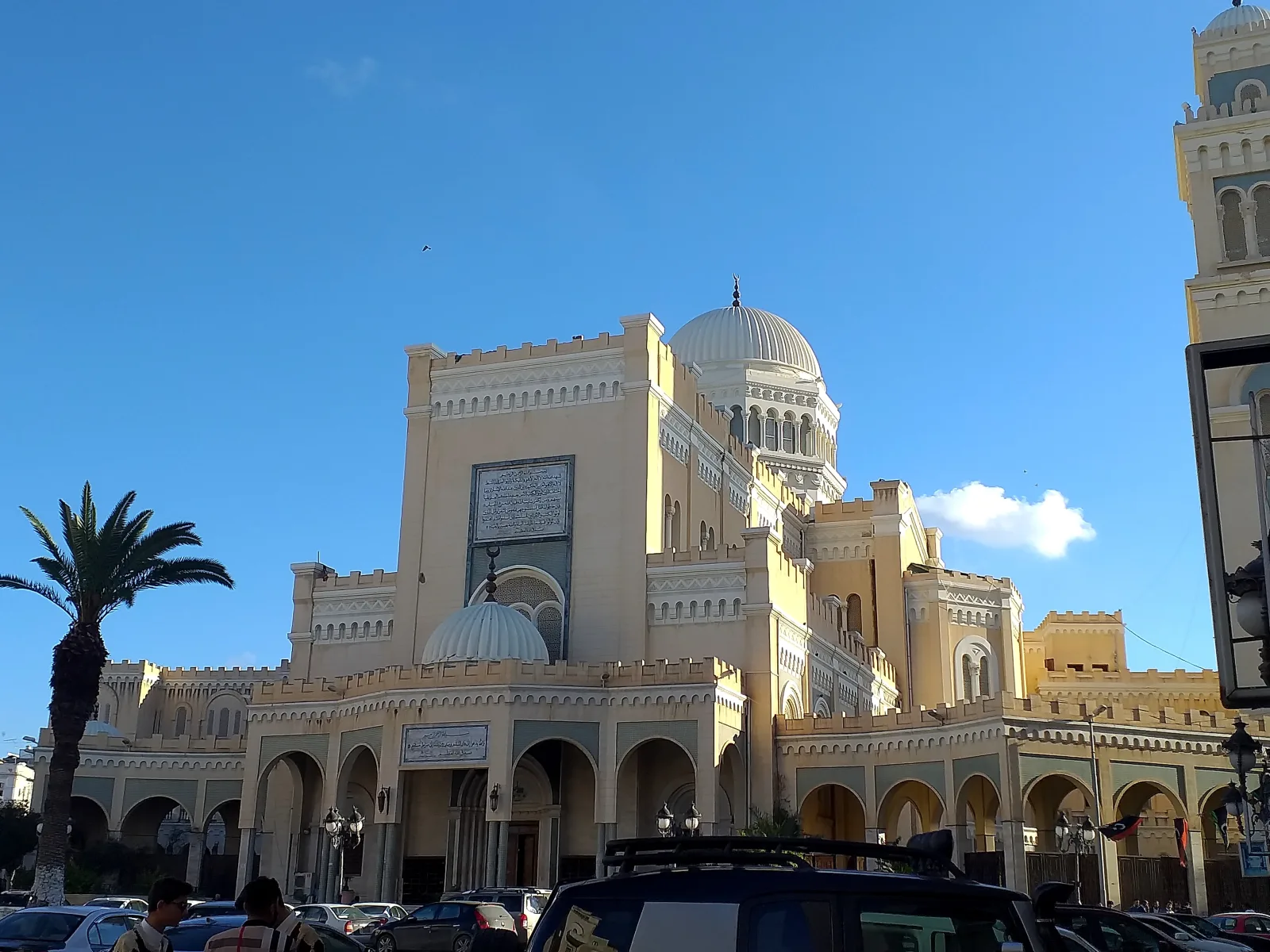 Vue du centre-ville de Tripoli, en Libye, avec une mosquée et un palmier au premier plan